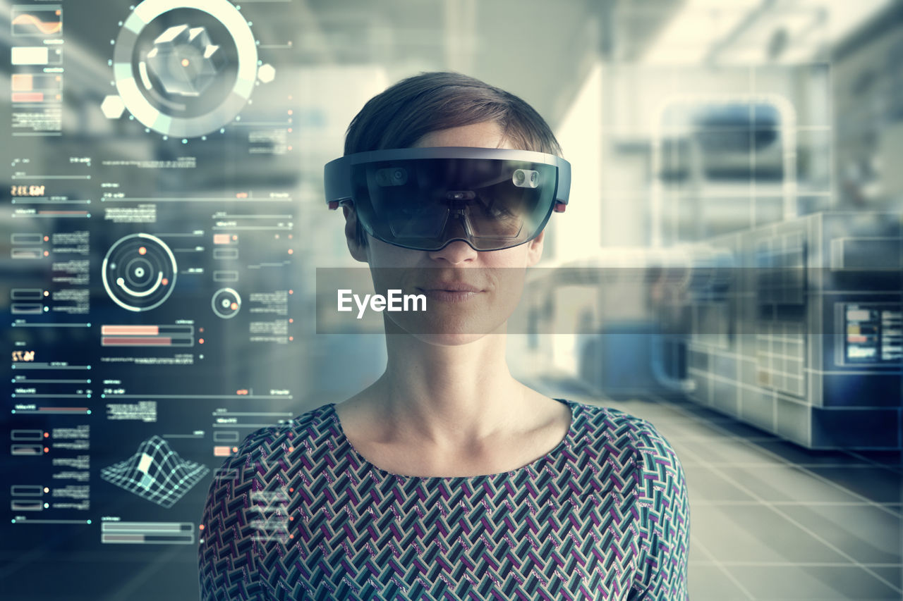 Woman wearing mixed reality smartglasses at transparent screen