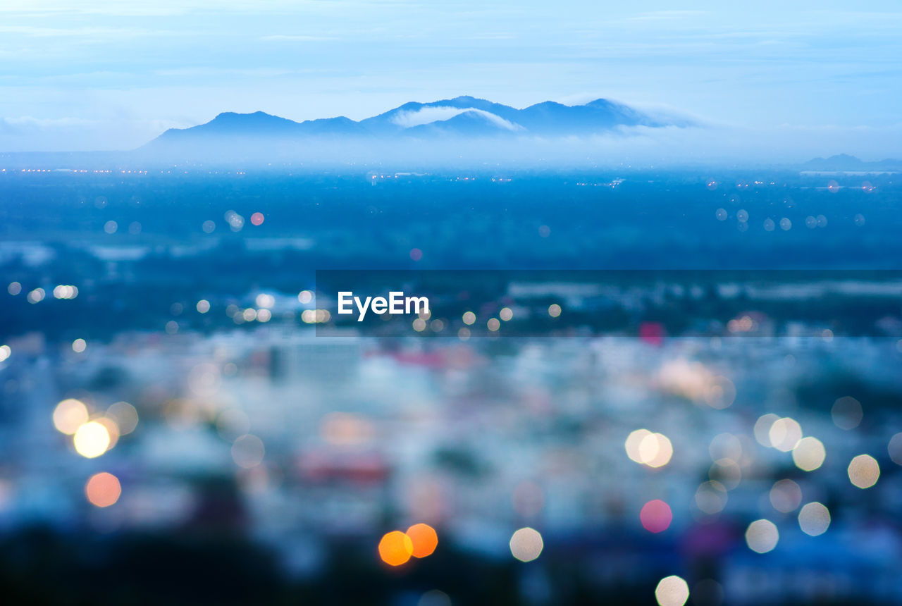 sky, city, no people, illuminated, water, scenics - nature, sea, cloud - sky, beauty in nature, nature, outdoors, tranquil scene, tranquility, building exterior, architecture, cityscape, mountain, aerial view, high angle view