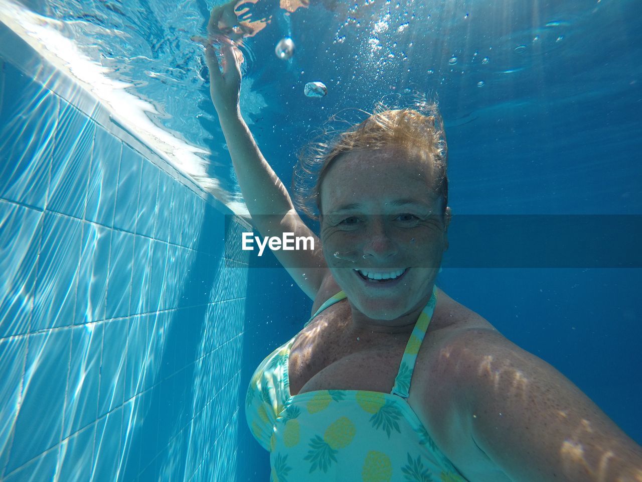 Portrait of smiling woman swimming in pool