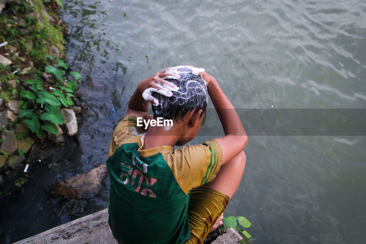High angle view of boy playing in lake