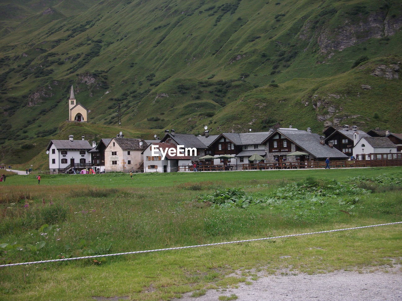 Houses on field by mountain