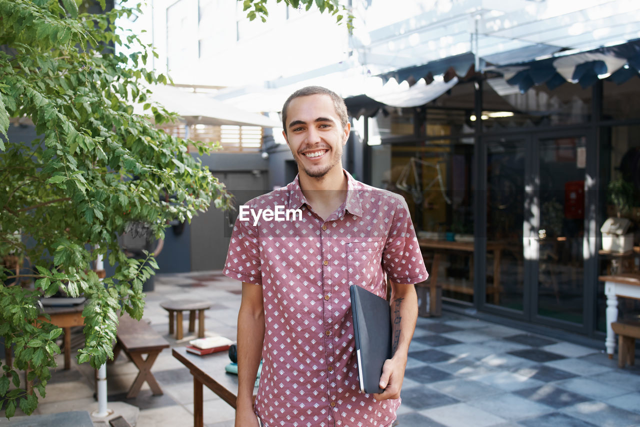 Portrait of young man with laptop