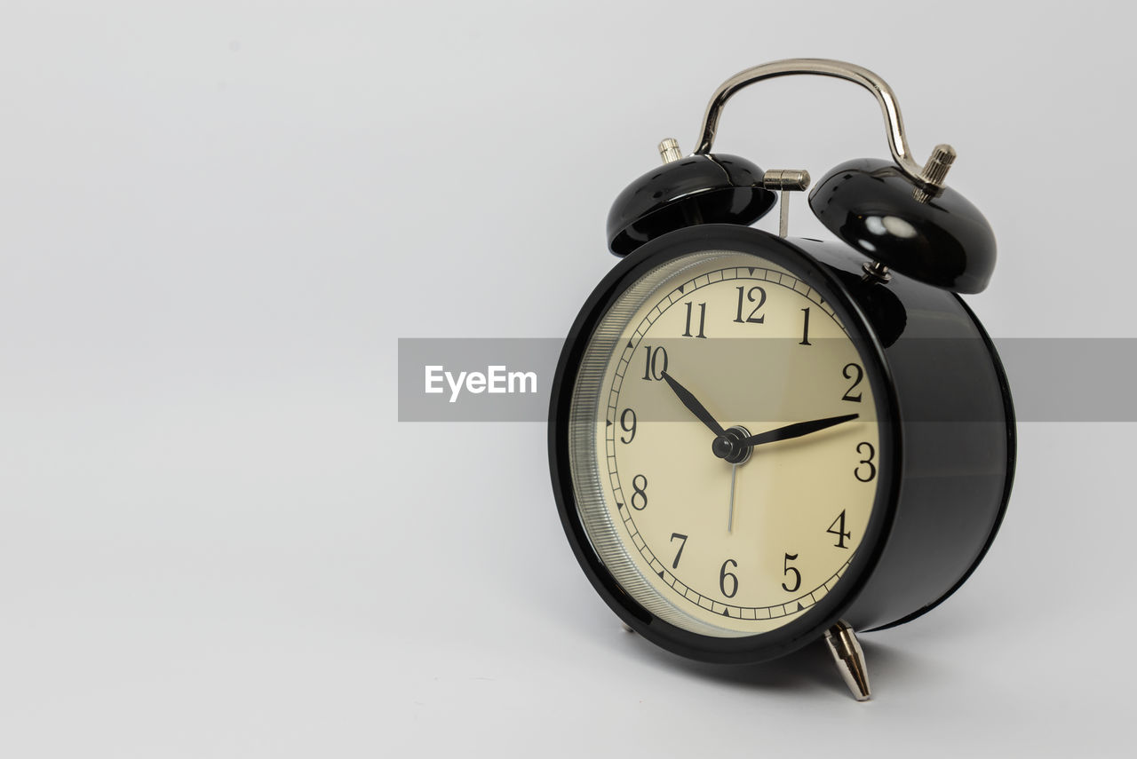 CLOSE-UP OF CLOCK ON WHITE BACKGROUND