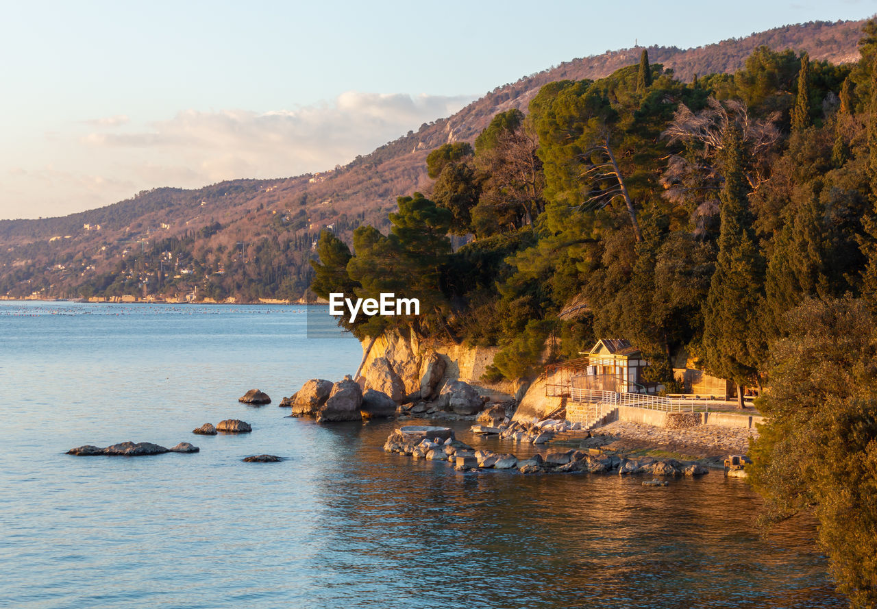 SCENIC VIEW OF SEA BY MOUNTAINS AGAINST SKY