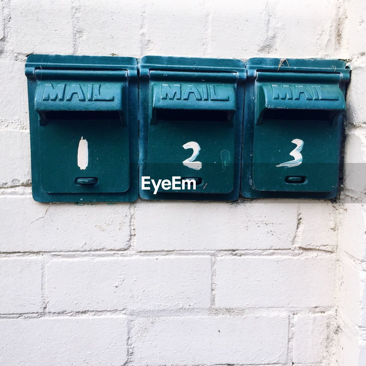 CLOSE-UP OF MAILBOX ON WHITE WALL