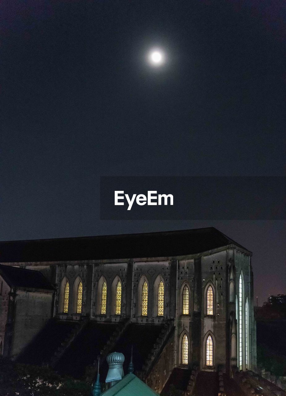 LOW ANGLE VIEW OF ILLUMINATED LIGHTS AGAINST SKY AT NIGHT