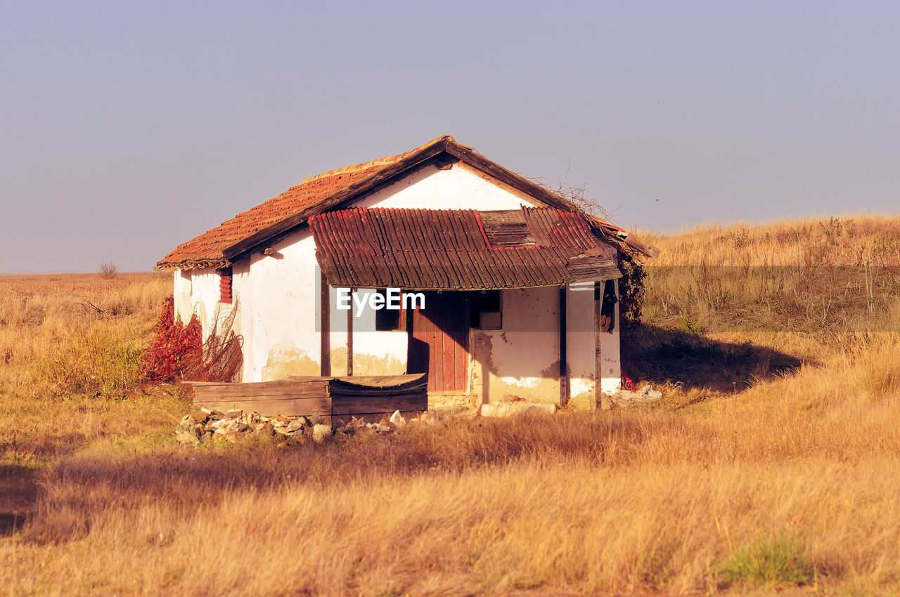 house on grassy field against clear sky