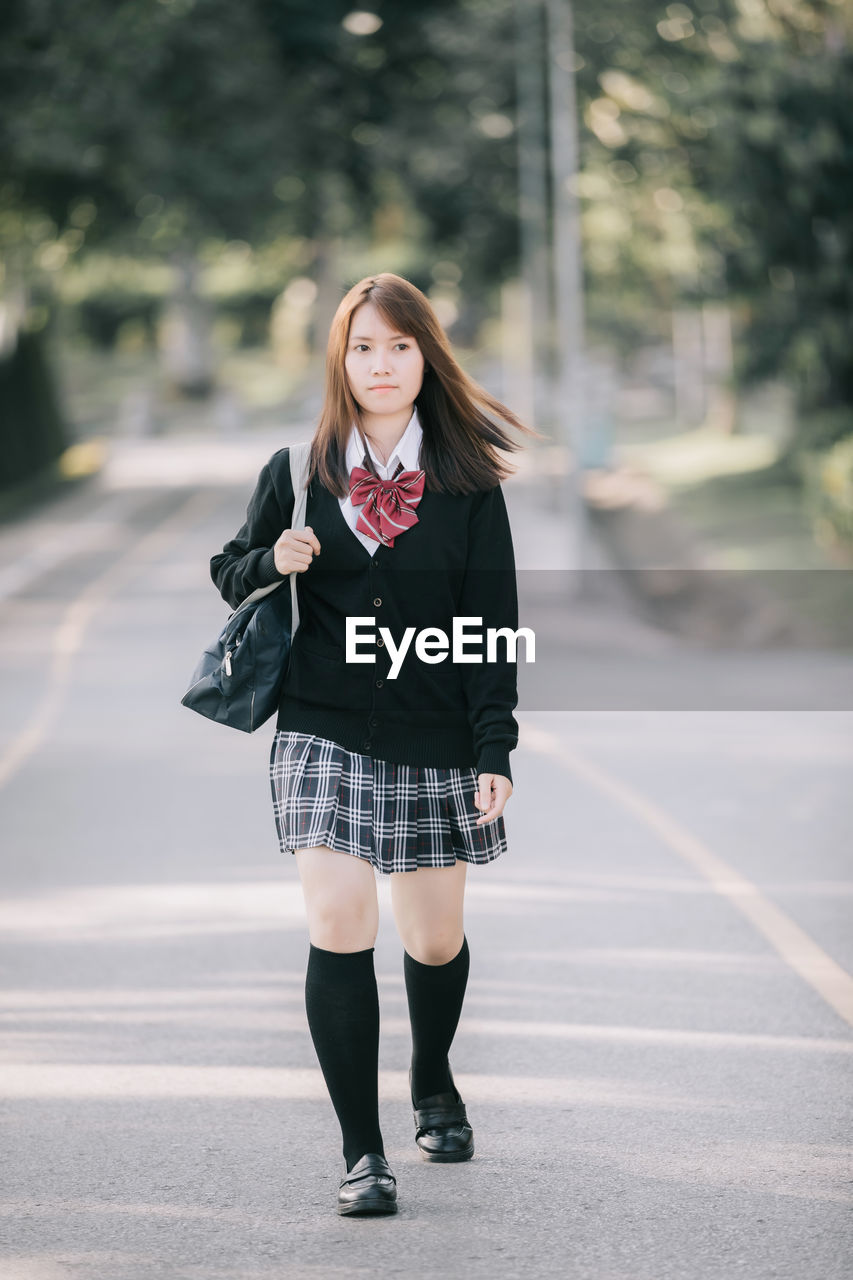 PORTRAIT OF BEAUTIFUL WOMAN STANDING ON ROAD