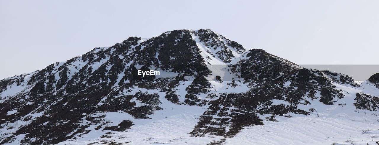 LOW ANGLE VIEW OF SNOW COVERED MOUNTAIN AGAINST SKY