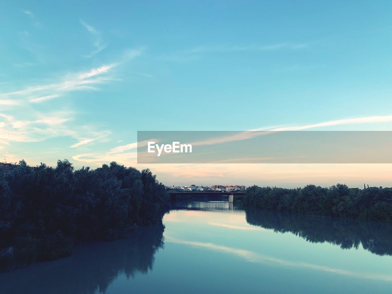 Scenic view of river against sky at sunset