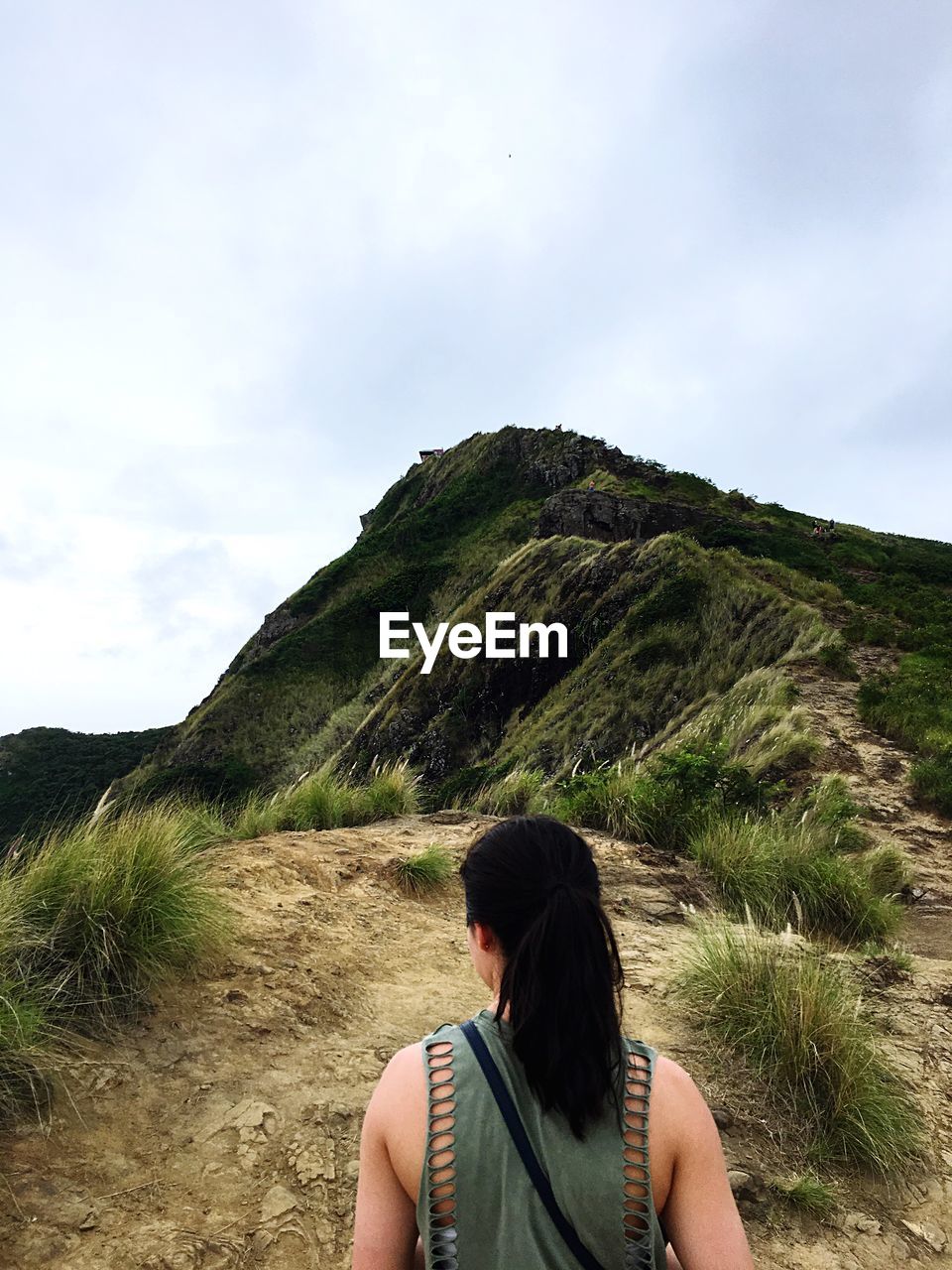 Rear view of mature woman looking at mountain against sky