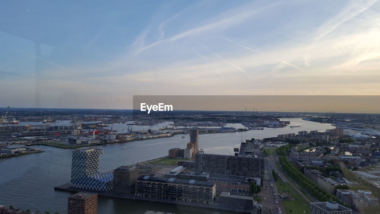 HIGH ANGLE VIEW OF RIVER AMIDST BUILDINGS IN CITY