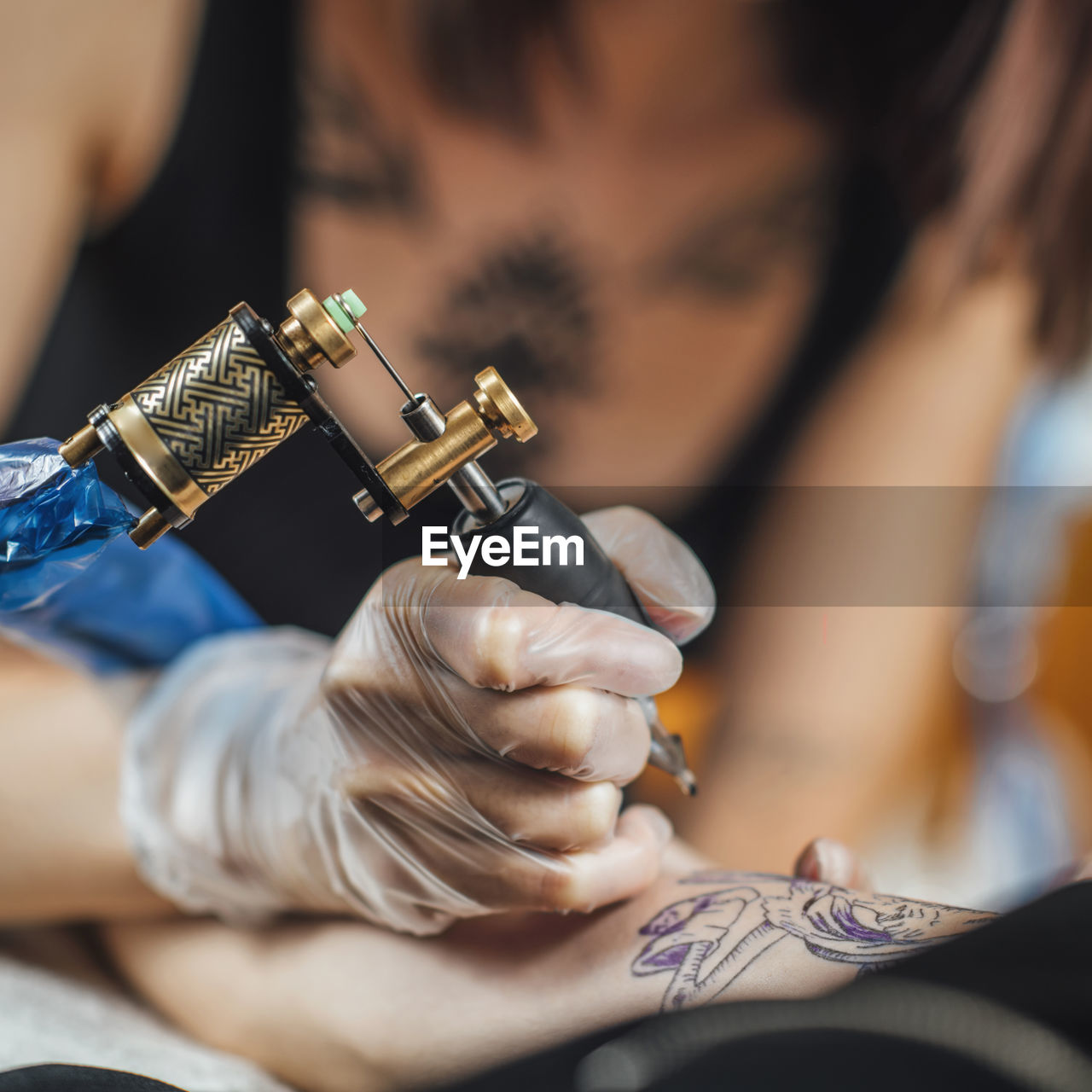 Tattoo machine close up. tattoo artist creating tattoo on a man's arm