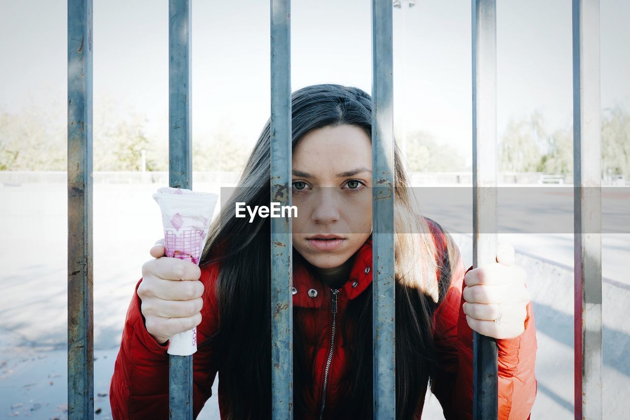 Young woman standing in front of gate