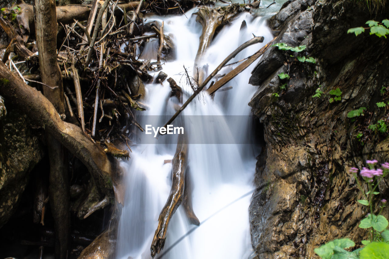 CLOSE-UP OF WATERFALL ON ROCKS