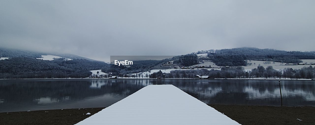 SCENIC VIEW OF LAKE AND MOUNTAINS AGAINST SKY DURING WINTER