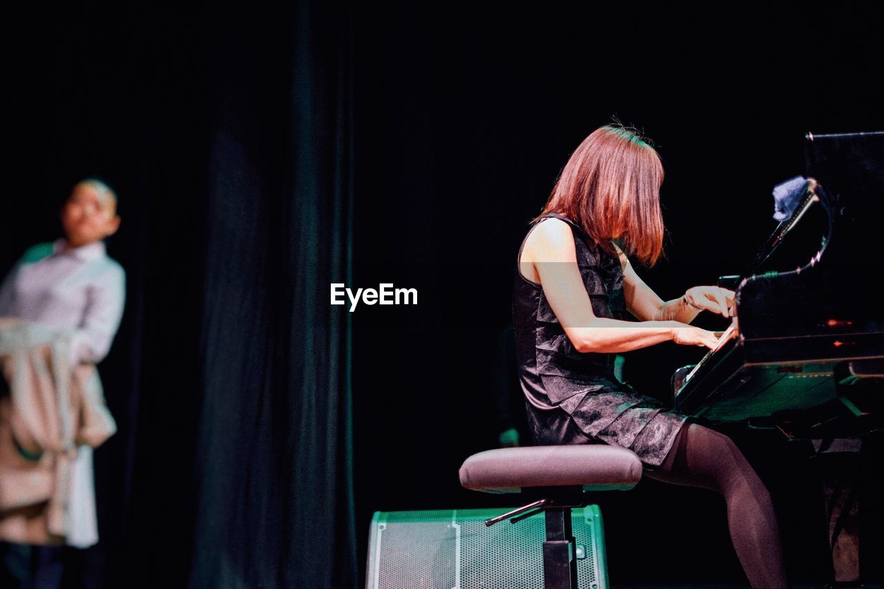 Woman playing piano on stage