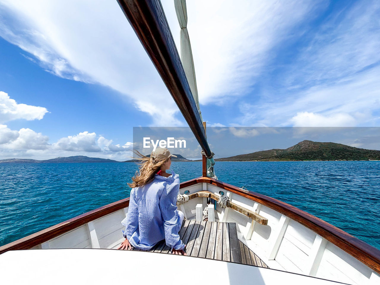 water, transportation, sea, nautical vessel, mode of transportation, travel, sailing, vacation, holiday, boat, trip, ship, sky, luxury, sailboat, nature, yacht, adult, vehicle, boat deck, sailing ship, deck, summer, watercraft, leisure activity, yachting, cloud, relaxation, journey, beauty in nature, cruise, one person, travel destinations, wealth, blue, adventure, passenger ship, women, windsports, scenics - nature, environment, day, sunlight, tourism, lifestyles, outdoors, motion, sailor, young adult, wind, recreation, craft, happiness, activity, men, sports, tourist, casual clothing, mountain