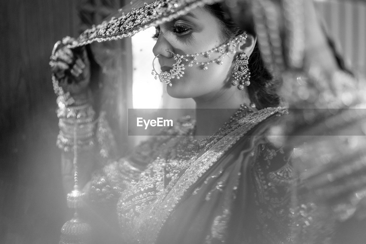 women, adult, fashion, one person, clothing, black and white, bride, portrait, young adult, female, monochrome photography, dress, monochrome, white, selective focus, fashion accessory, elegance, veil, jewelry, celebration, photo shoot, glamour, hat, headshot, arts culture and entertainment, looking, wedding dress, shiny, black, nature, person, lifestyles, indoors