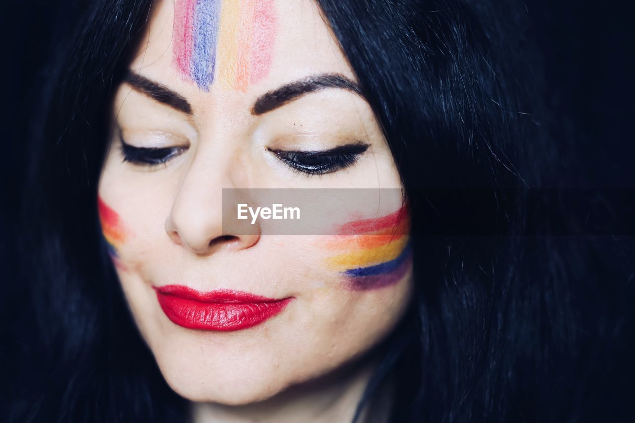 Close-up portrait of a beautiful young woman with rainbow makeup 