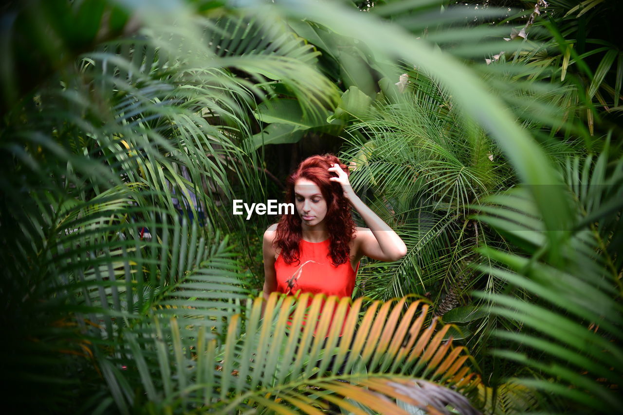 Portrait of young woman surrounded by plants