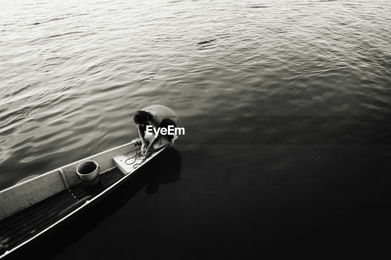 High angle view of man on boat moored in lake