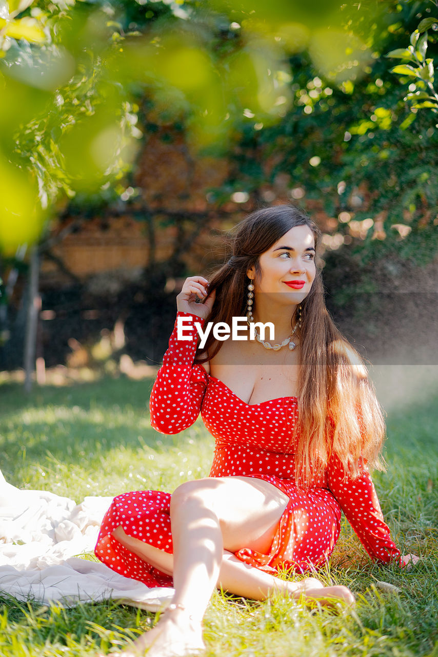 Portrait of young woman sitting on field