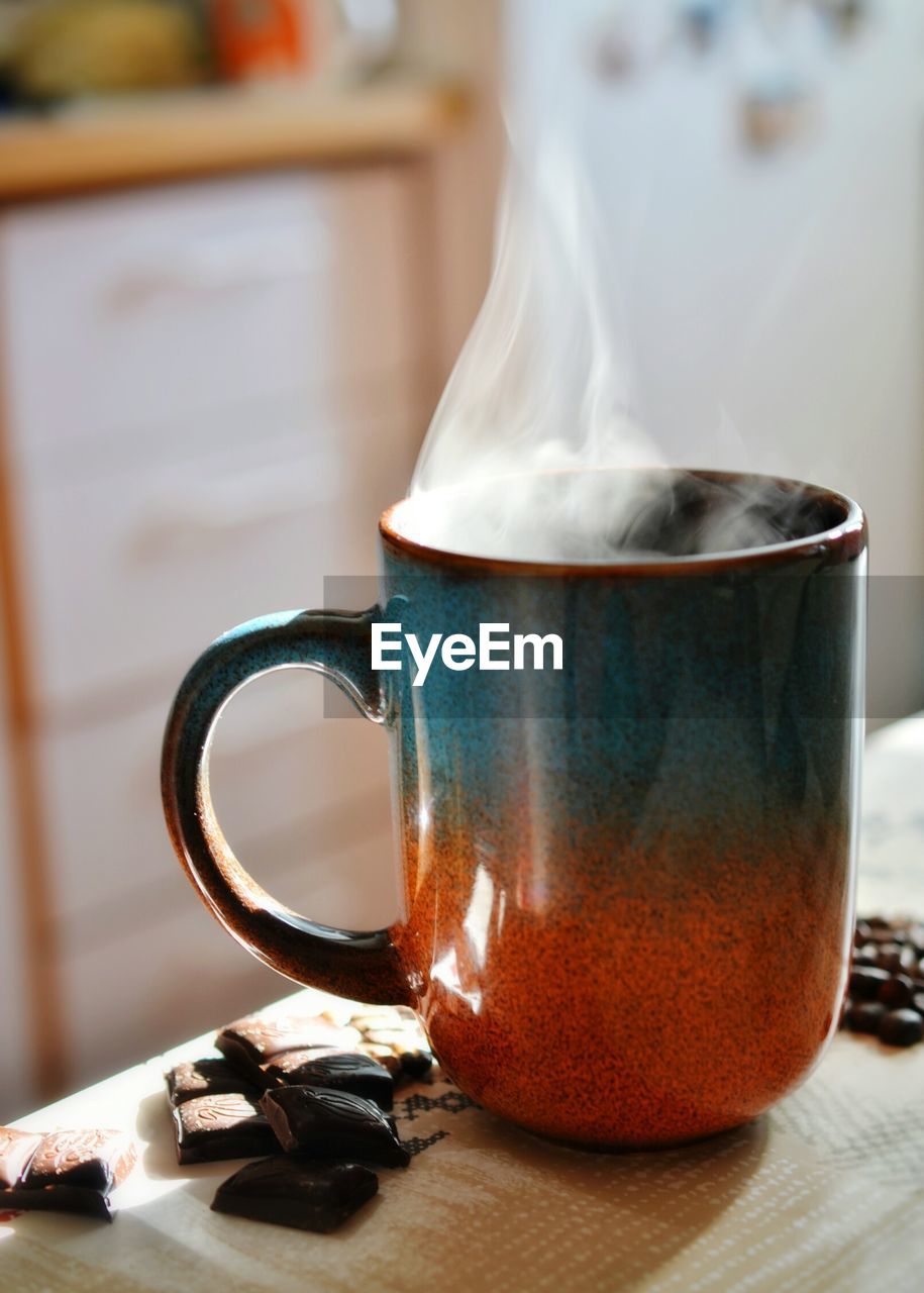 Close-up of fresh black coffee with chocolate on table