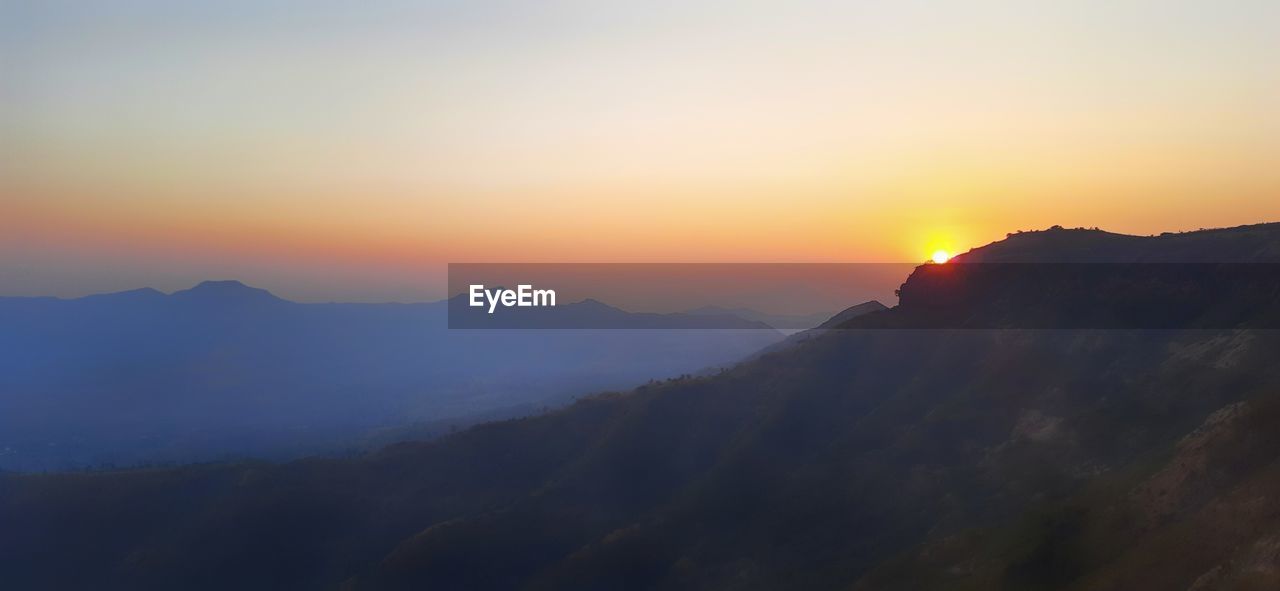 Scenic view of silhouette mountains against sky during sunset