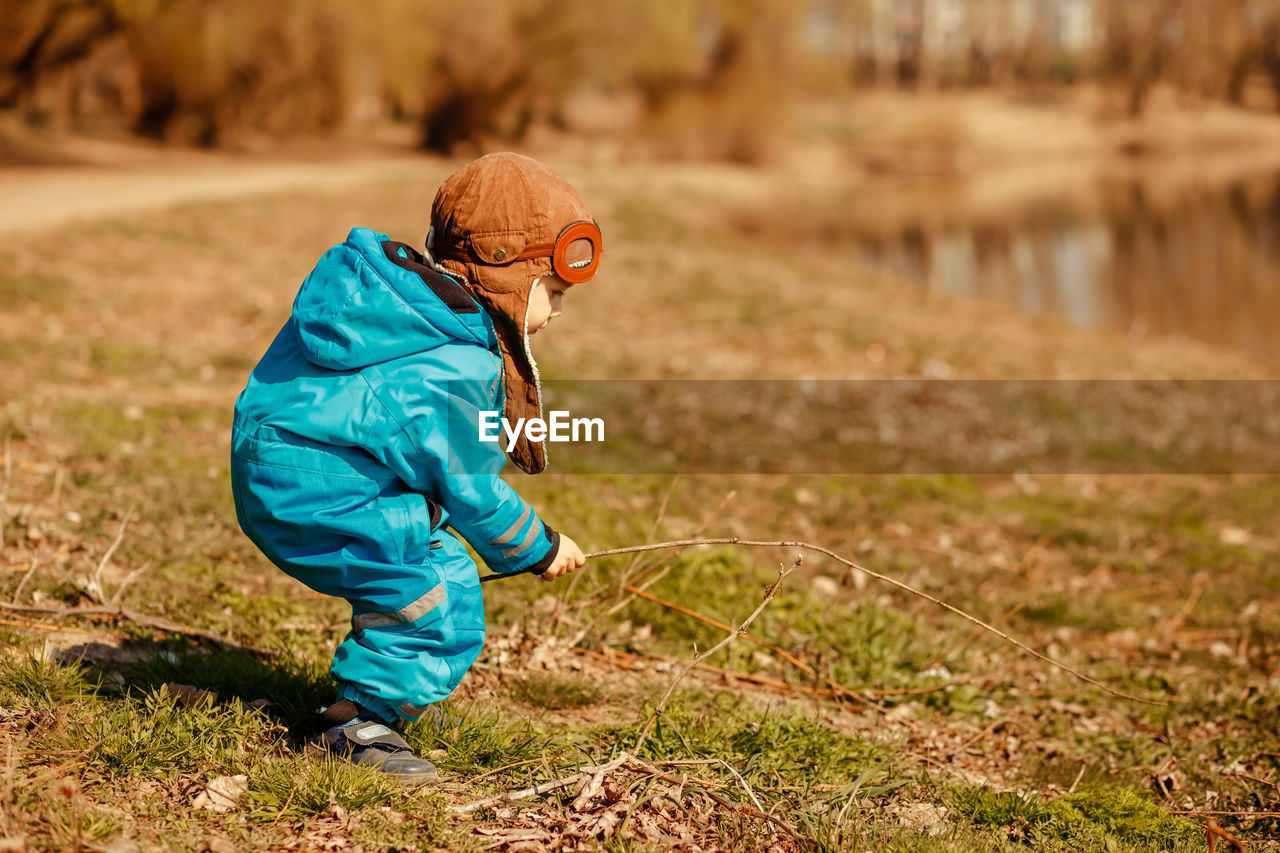 Side view of boy on field