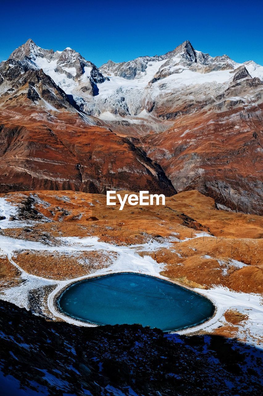 Scenic view of snowcapped mountains against blue sky
