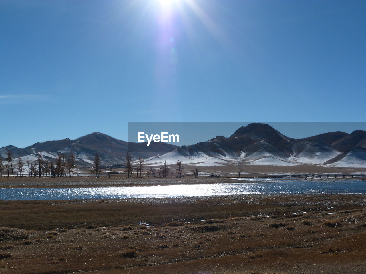 Scenic view of lake and mountains against clear sky