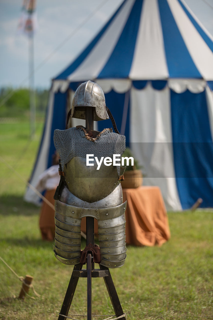 REAR VIEW OF TENT ON FIELD AGAINST YELLOW SKY