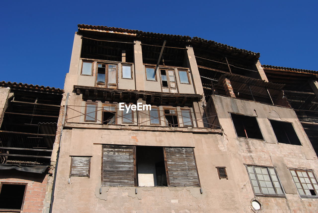 LOW ANGLE VIEW OF BUILDING ON SUNNY DAY