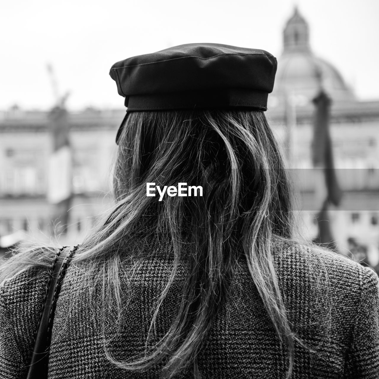 Rear view of woman wearing hat standing in city