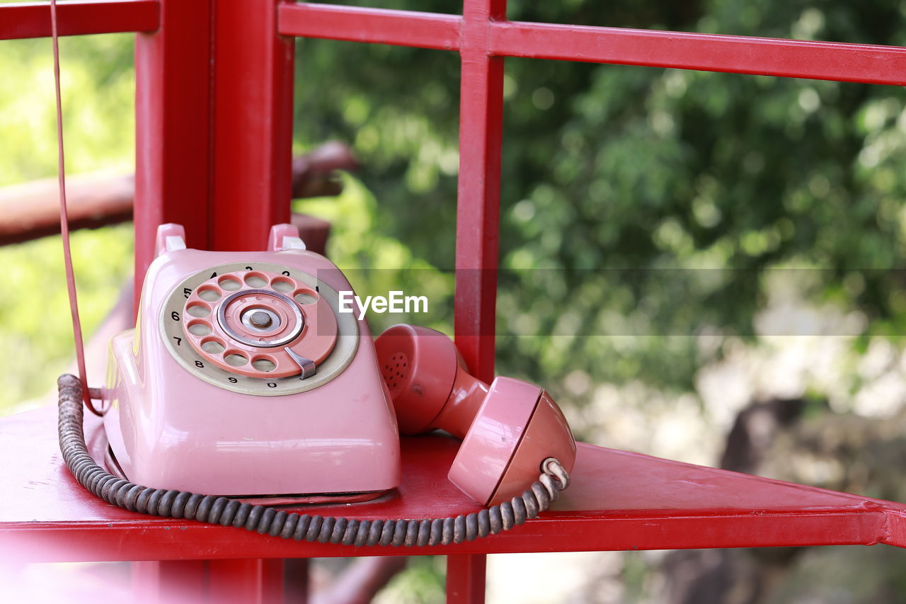 CLOSE-UP OF TELEPHONE BOOTH ON TABLE AGAINST BLURRED BACKGROUND