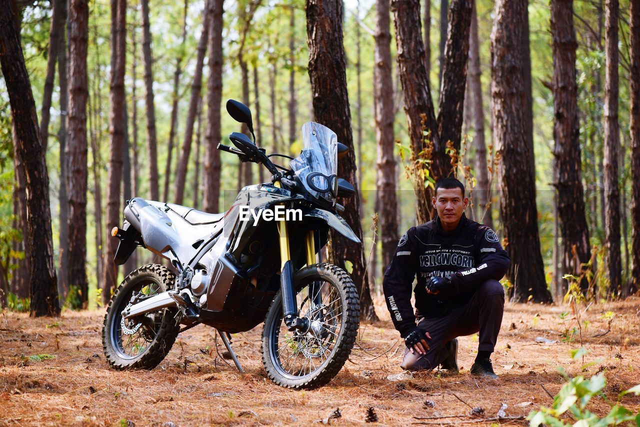 Man riding bicycle on dirt road in forest