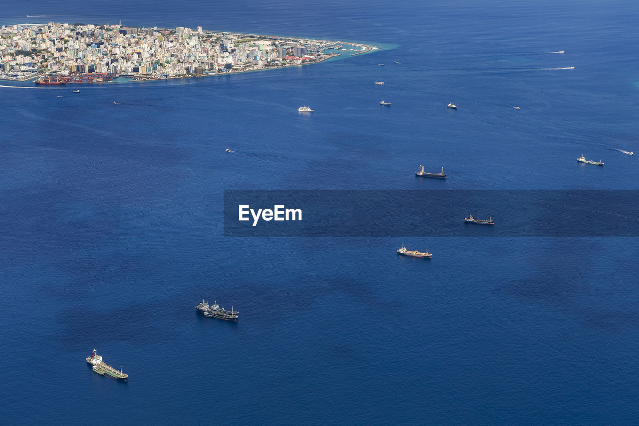 Cargo ships floating near the male city capital of maldives, view from seaplane window