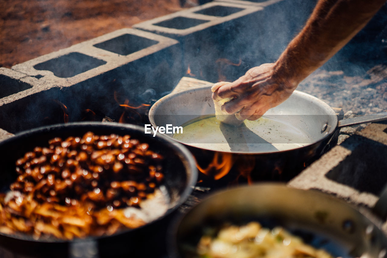 Close-up of person hand preparing food on barbecue grill