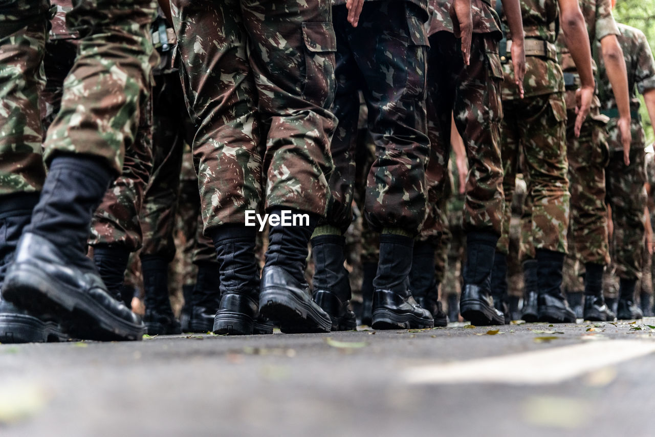  low view of the legs of brazilian army soldiers marching through the streets 