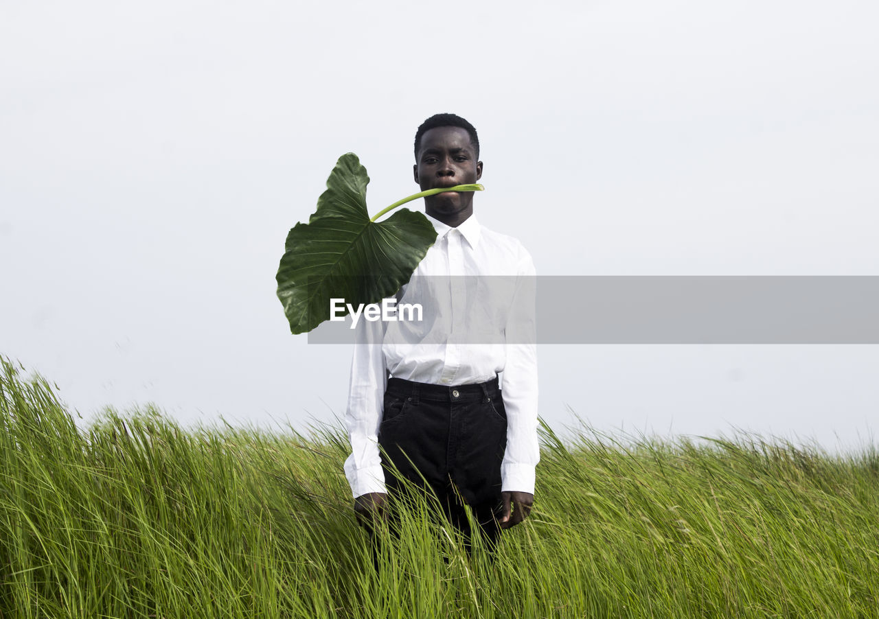 FULL LENGTH OF YOUNG MAN STANDING ON FIELD