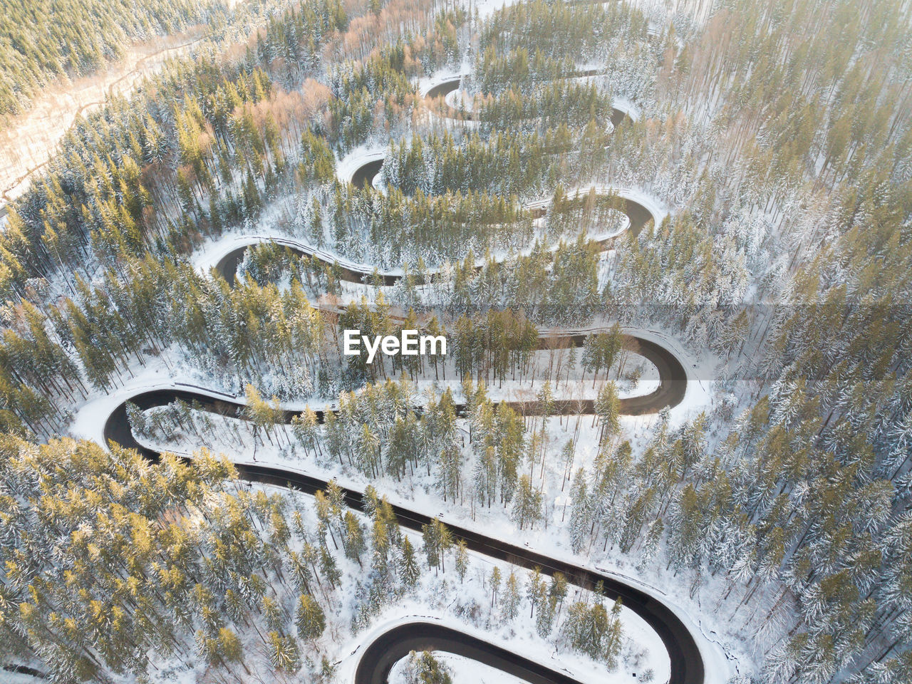 Aerial view of a snow-covered forest road