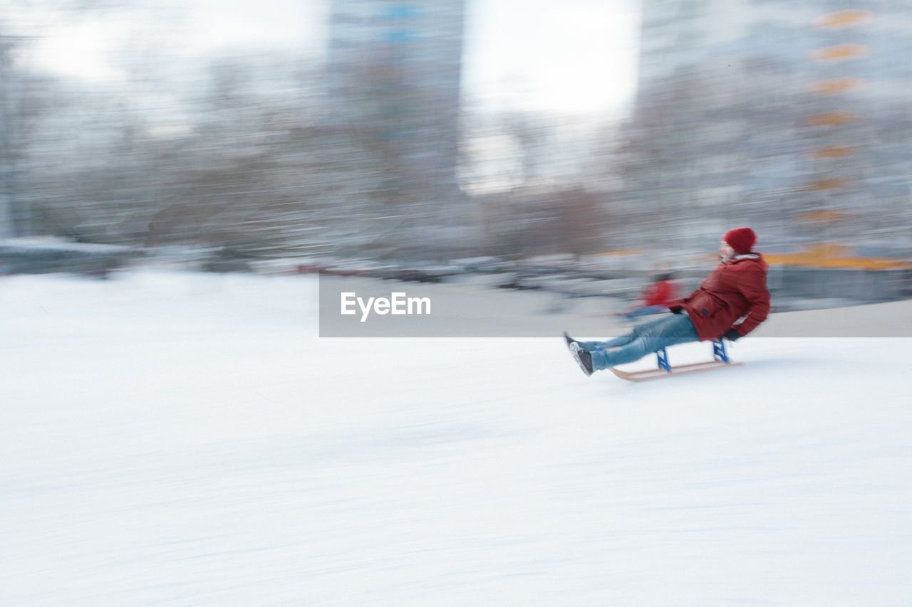 Rear view of boy riding motorcycle on snow