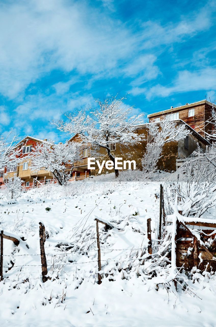 SNOW COVERED LANDSCAPE AGAINST HOUSES