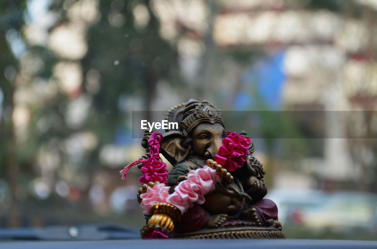 Close-up of ganesha figurine on car dashboard