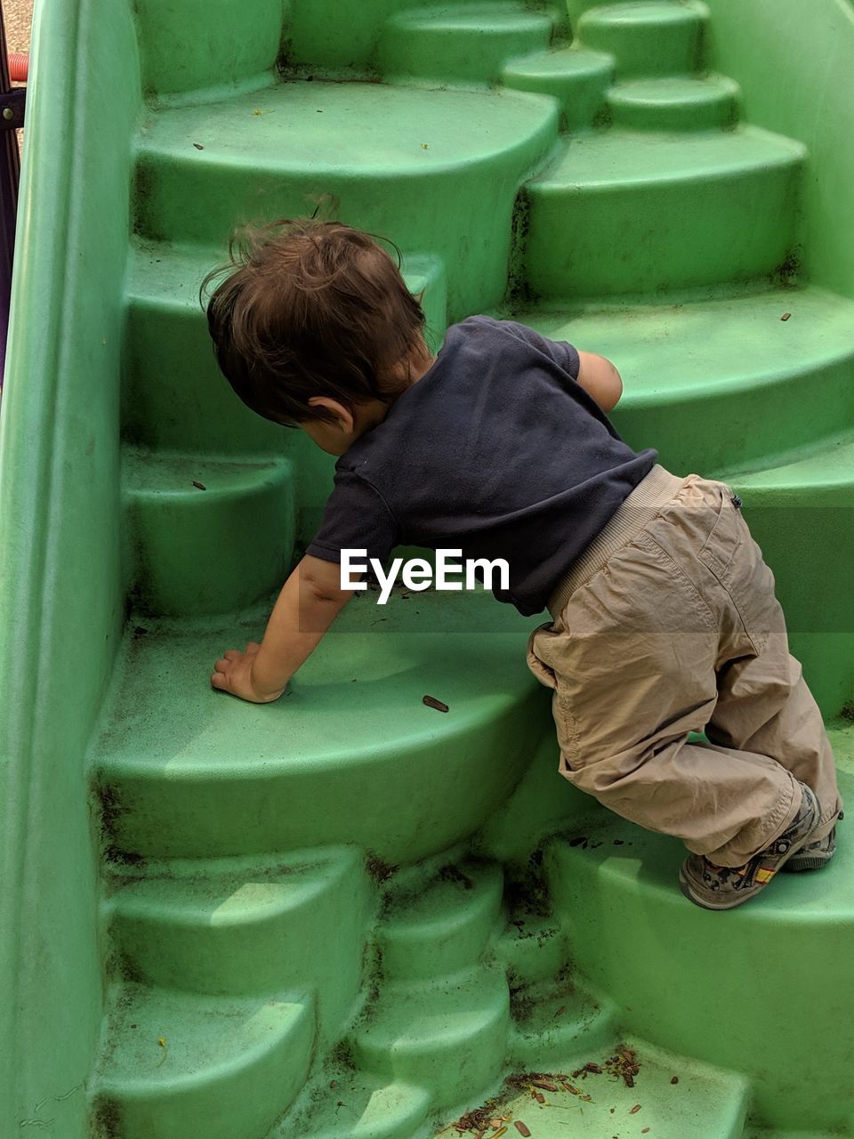 High angle view of boy climbing a play structure 