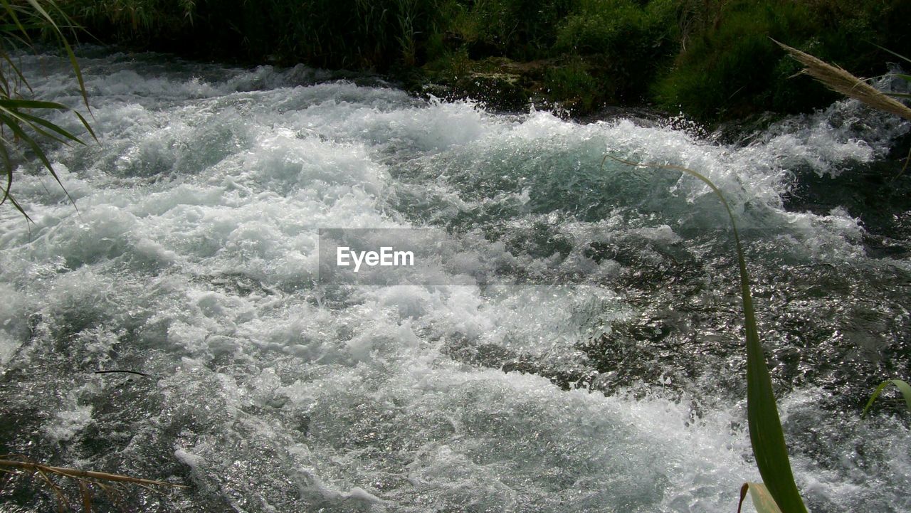 WATER FLOWING THROUGH ROCKS IN RIVER
