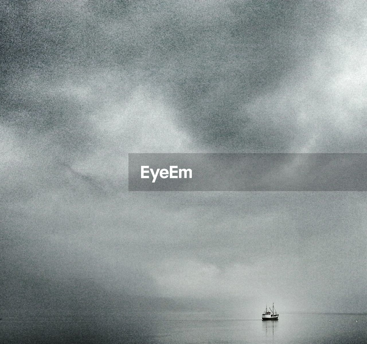 Scenic view of ship in sea against cloudy sky