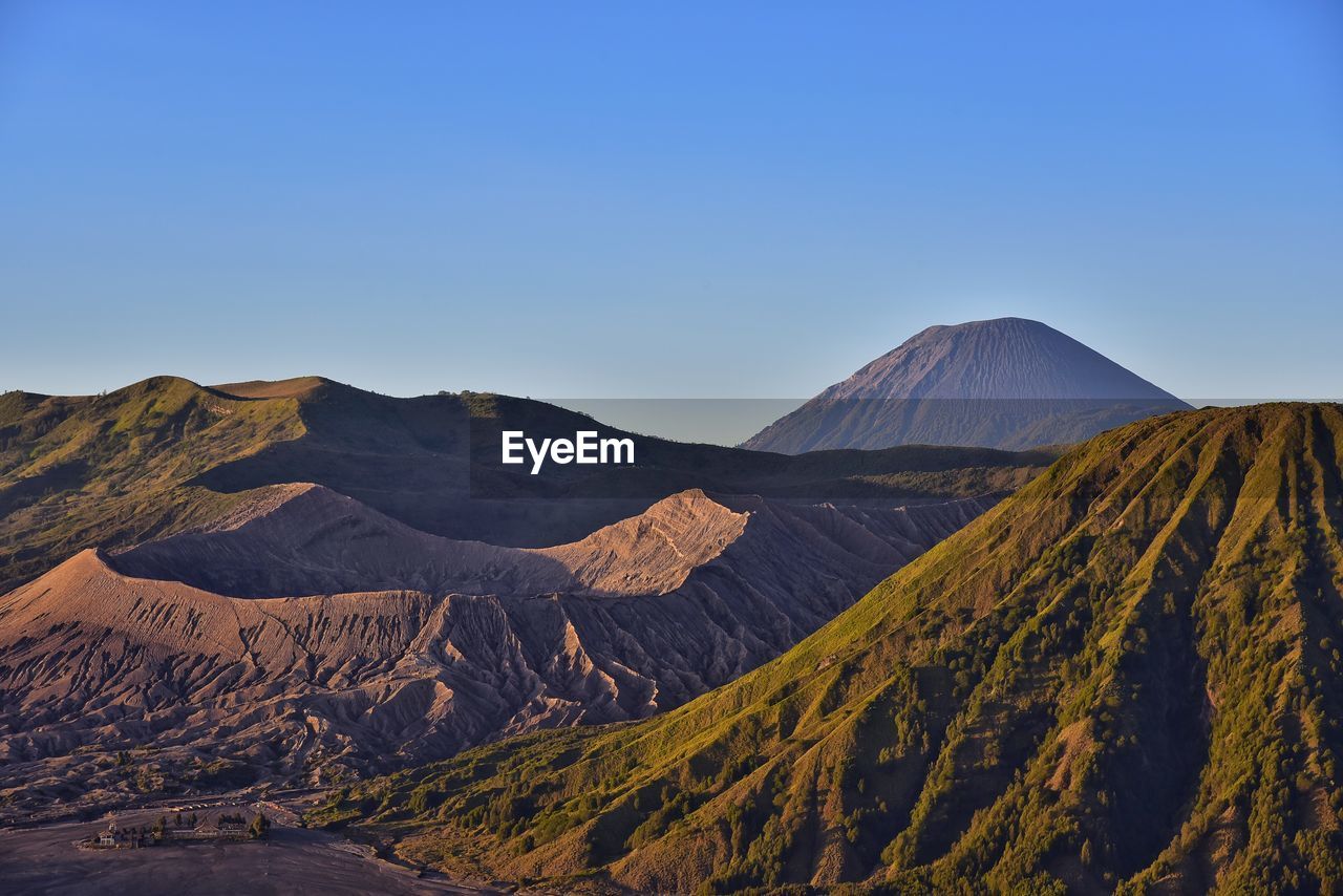 Scenic view of volcanic landscape against clear blue sky