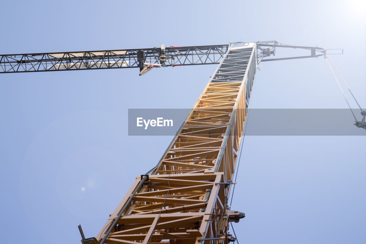 LOW ANGLE VIEW OF CRANE AT CONSTRUCTION SITE AGAINST CLEAR SKY